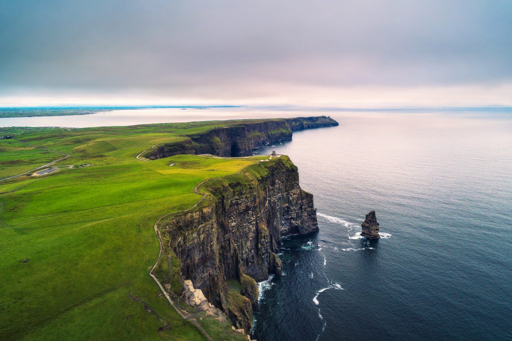 the grass covered cliffs of Moher jut out from the sea