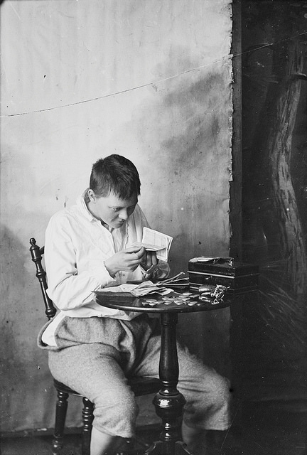 a young man or woman looking at money at outdoor table