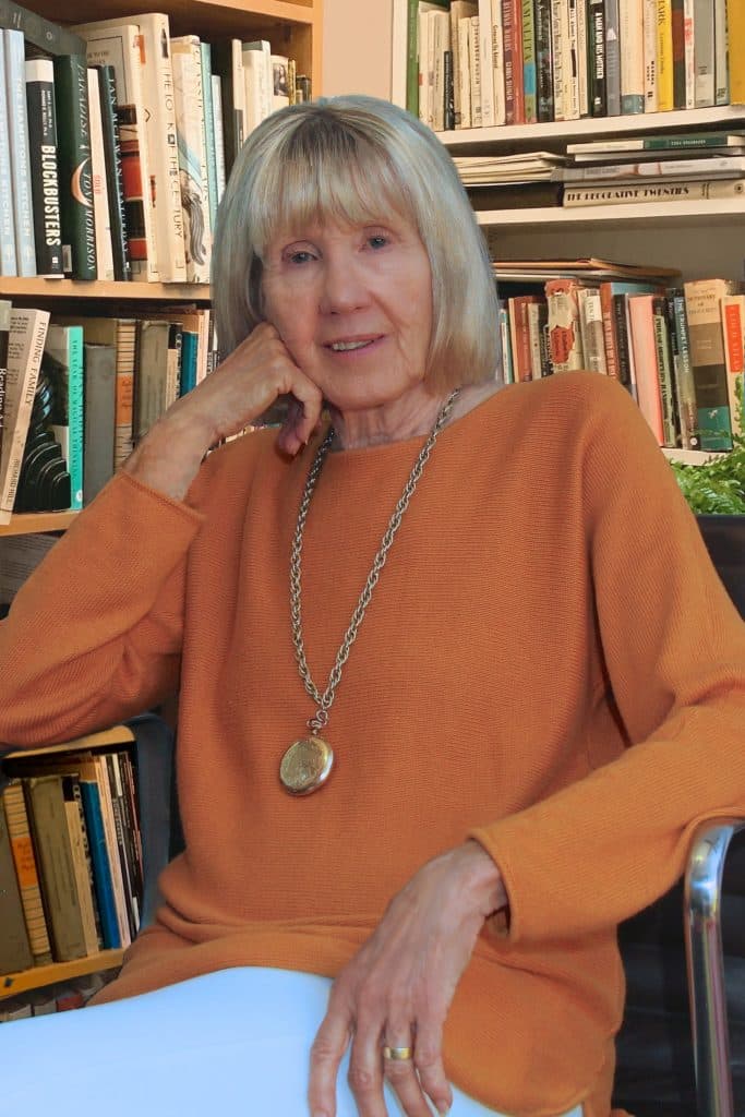 Lorraine Dusky sitting in front of a bookcase
